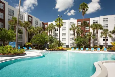 a swimming pool in front of a building with palm trees at Four Points by Sheraton Orlando Convention Center in Orlando