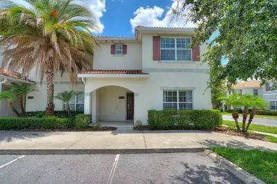 a large white house with palm trees and a driveway at Refurbished! Lazy Life At Storey Lake By Shine Villas #901 in Kissimmee