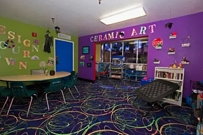 a classroom with purple walls and a table and chairs at Westgate Blue Tree Resort in Orlando