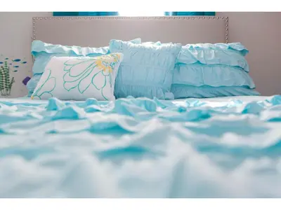 a bed with blue and white sheets and pillows at Best place to unwind and have lots of fun! in Kissimmee