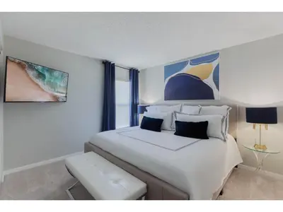 a bedroom with a large white bed and a window at Best place to unwind and have lots of fun! in Kissimmee