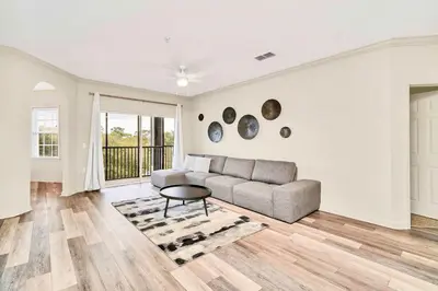 a living room with a couch and a table at Upstay Condo with Outdoor Pool & Sauna in Orlando