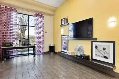 a lobby with a flat screen tv on a yellow wall at Orlando Palms in Orlando