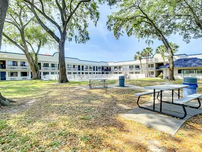 a park with two benches and a building at Stayable Kissimmee West in Kissimmee