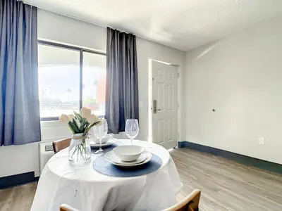 a dining room with a white table with chairs and a window at Stayable Kissimmee West in Kissimmee