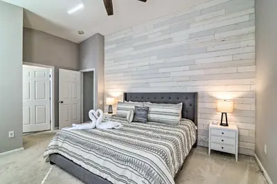 a bedroom with a large bed with a wooden wall at 5 Mi to Disney World Retreat with Pool and Lanai! in Kissimmee