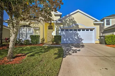 a house with a driveway and a garage at 5 Mi to Disney World Retreat with Pool and Lanai! in Kissimmee