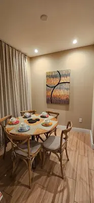 a dining room with a table and chairs and a painting at Magic Village 4 Bedroom! Welcome Home! in Orlando