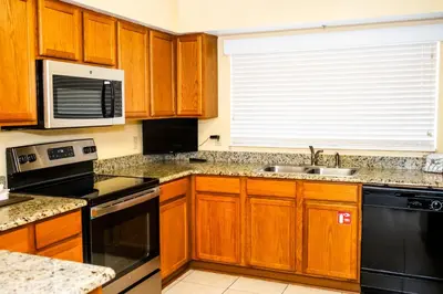 a kitchen with wooden cabinets and a sink at Silver Lake Resort in Orlando