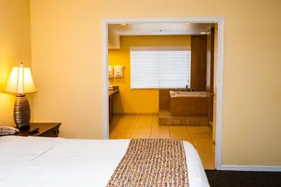 a bedroom with a bed and a bathroom with a tub at Silver Lake Resort in Orlando