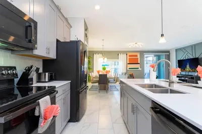 a kitchen with white cabinets and black appliances at Wonderful 5 Bd Close to Disney @ Storey Lake Resort 2980 in Kissimmee