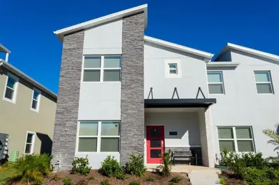 a white house with a red door at Wonderful 5 Bd Close to Disney @ Storey Lake Resort 2980 in Kissimmee