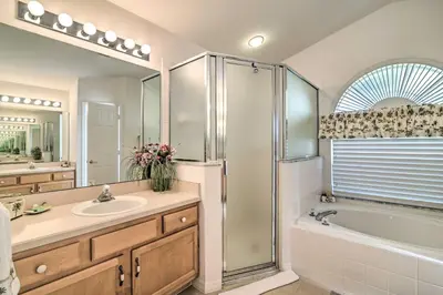 a bathroom with a tub and a sink and a shower at No Pet Fee! Snowbird Haven in Lake Worth Beach! in Orlando
