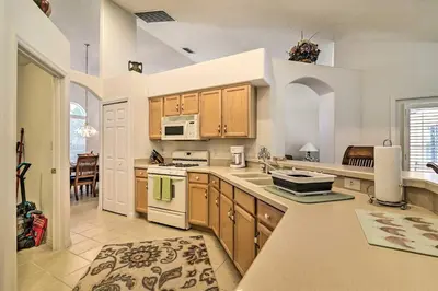 a kitchen with wooden cabinets and a stove top oven at No Pet Fee! Snowbird Haven in Lake Worth Beach! in Orlando