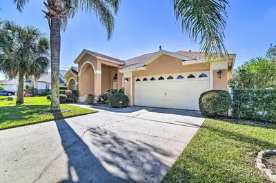 a house with a palm tree and a driveway at No Pet Fee! Snowbird Haven in Lake Worth Beach! in Orlando