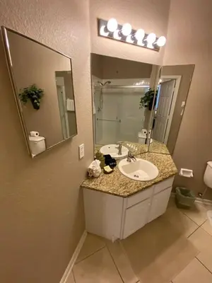 a bathroom with a sink and a large mirror at 3 bedroom Disney Condo Windsor Hills in Orlando