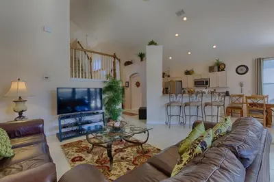 a living room with a couch and a tv and a kitchen at Resort 5 Bed Private Pool & Spa, Game Room Home villa in Kissimmee