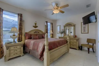 a bedroom with a bed and a ceiling fan at Resort 5 Bed Private Pool & Spa, Game Room Home villa in Kissimmee