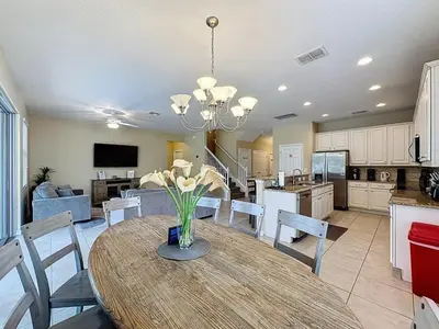a kitchen and dining room with a table and chairs at Veranda Home, 8br, 6 en-suites, Lake View,POOL SPA villa in Kissimmee