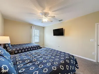 a bedroom with a bed and a ceiling fan at Veranda Home, 8br, 6 en-suites, Lake View,POOL SPA villa in Kissimmee