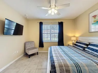 a bedroom with a bed and a ceiling fan at Veranda Home, 8br, 6 en-suites, Lake View,POOL SPA villa in Kissimmee
