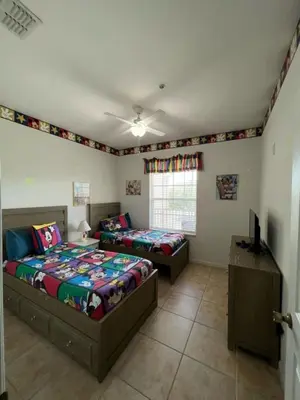 a bedroom with two beds and a television in it at Amazing Resort 2 bed condo close to Disney condo in Kissimmee