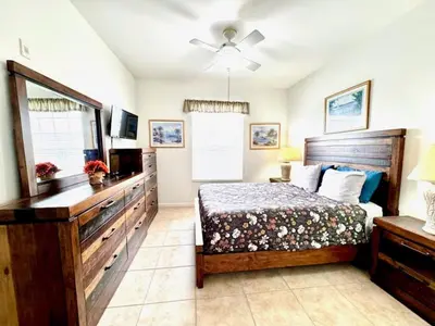 a bedroom with a bed and a dresser and a television at Amazing Resort 2 bed condo close to Disney condo in Kissimmee