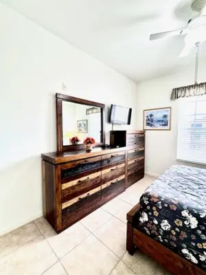 a bedroom with a dresser with a mirror and a bed at Amazing Resort 2 bed condo close to Disney condo in Kissimmee
