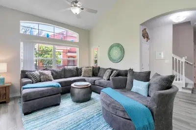 a living room with a couch and a table at Disney Area 4 bed 3,5 Bathroom Emerald Island townhouse in Kissimmee