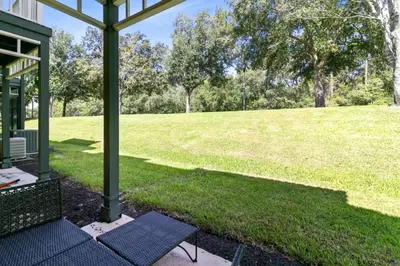 a porch with a lawn with a field in the background at Disney Area 4 bed 3,5 Bathroom Emerald Island townhouse in Kissimmee