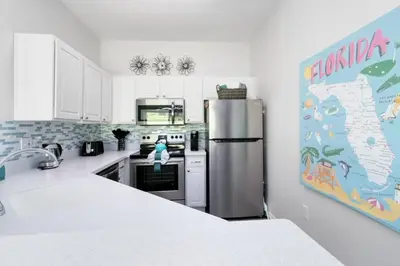 a kitchen with a refrigerator and a map on the wall at Disney Area 4 bed 3,5 Bathroom Emerald Island townhouse in Kissimmee