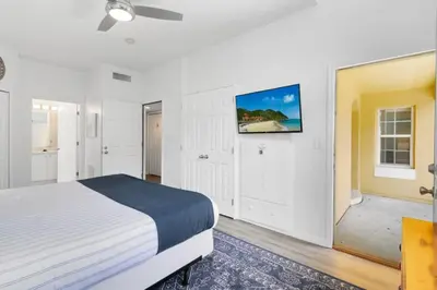 a bedroom with a bed and a tv on the wall at Disney Area 4 bed 3,5 Bathroom Emerald Island townhouse in Kissimmee