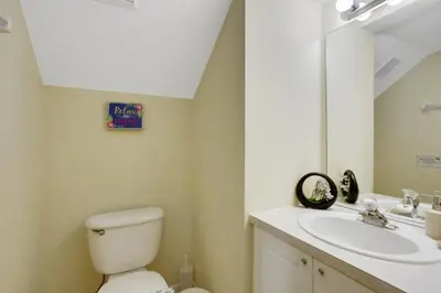 a bathroom with a toilet and a sink and a mirror at Fantastic Resort 5BR House - South Facing Pool Spa villa in Kissimmee