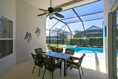 a dining room with a table and chairs and a pool at Fantastic Resort 5BR House - South Facing Pool Spa villa in Kissimmee