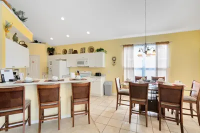 a kitchen and dining room with a table and chairs at Fantastic Resort 5BR House - South Facing Pool Spa villa in Kissimmee