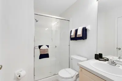 a bathroom with a shower and a toilet and a sink at 4 Bedroom 3 Bath South Facing Pool Spa Villa villa in Kissimmee