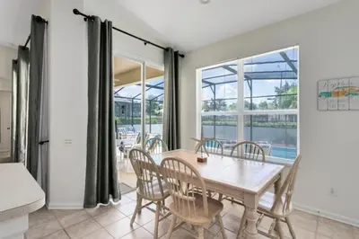 a dining room with a table and chairs at 4 Bedroom 3 Bath South Facing Pool Spa Villa villa in Kissimmee