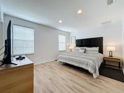 a bedroom with a bed and a flat screen tv at Amazing Townhouse close to Disney 2 Bed 2,5 Bath townhouse in Kissimmee