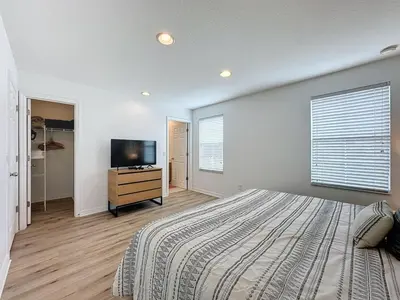 a bedroom with a bed and a flat screen tv at Amazing Townhouse close to Disney 2 Bed 2,5 Bath townhouse in Kissimmee
