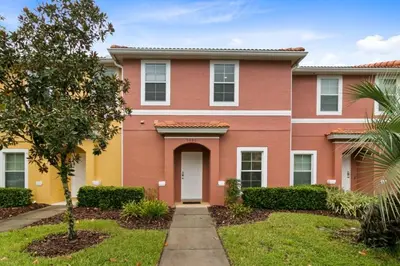 a house with a pink and yellow house at Amazing Townhouse close to Disney 2 Bed 2,5 Bath townhouse in Kissimmee
