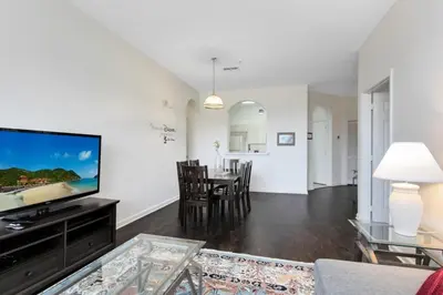 a living room with a television and a table with chairs at Windsor Palms 3 bed Condo in Gated Resort condo in Kissimmee
