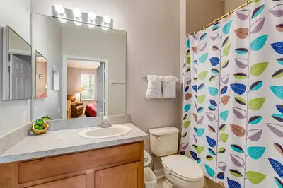 a bathroom with a sink and a toilet and a shower curtain at The Great Escape - A spacious 1st floor condo on Windsor Palms Resort - close to Disney in Kissimmee