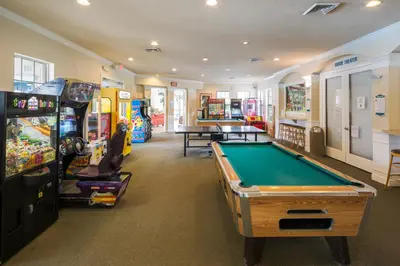 a room with a pool table and arcade games at The Great Escape - A spacious 1st floor condo on Windsor Palms Resort - close to Disney in Kissimmee