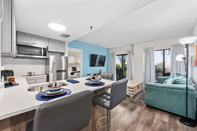 a kitchen and living room with a table and chairs at Exclusive Ground-Floor Apartment in Orlando