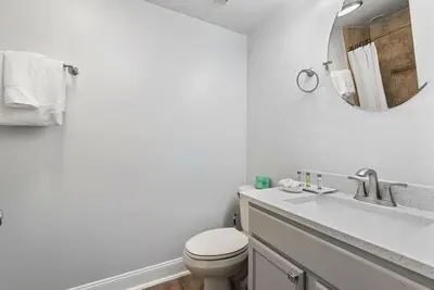 a white bathroom with a toilet and a mirror at Exclusive Ground-Floor Apartment in Orlando