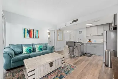 a living room with a blue couch and a kitchen at Exclusive Ground-Floor Apartment in Orlando