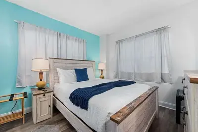 a bedroom with a bed and a blue wall at Exclusive Ground-Floor Apartment in Orlando