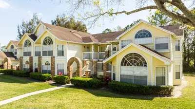 a large yellow house with a landscaping at Beautiful, cozy and spacious Retreat near Disney in Kissimmee
