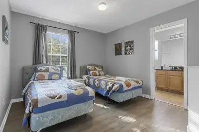 a bedroom with two beds and a sink at 8503 Themed 7BD Villa- Game room Poolspa in Kissimmee