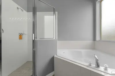 a white bathroom with a shower and a sink at 8503 Themed 7BD Villa- Game room Poolspa in Kissimmee